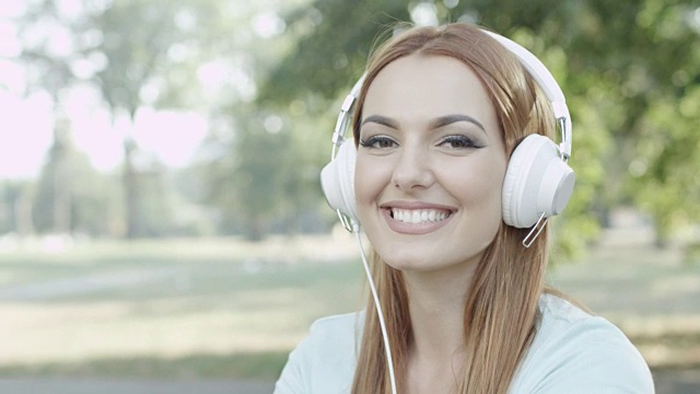 公园里戴着耳机的年轻女子视频素材