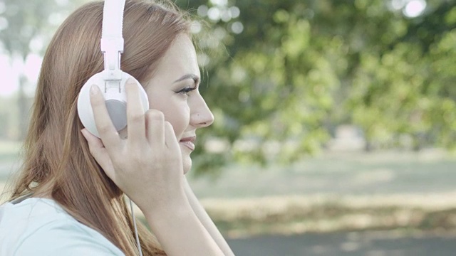 公园里戴着耳机的年轻女子视频素材