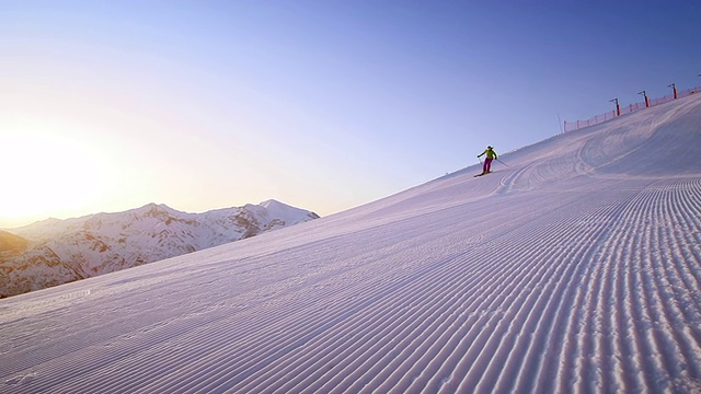 SLO MO女子滑雪者在新鲜的早晨轨道在日出视频素材