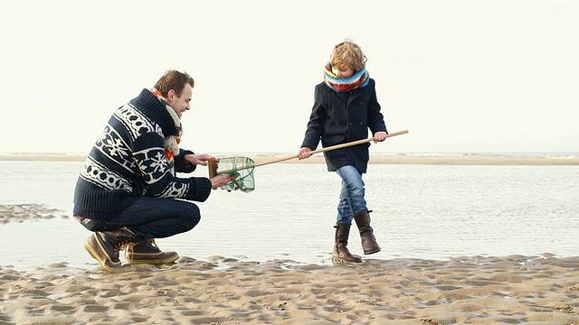 父亲和儿子在海滩上玩风筝视频下载