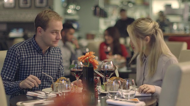 年轻夫妇在餐馆享受食物视频素材