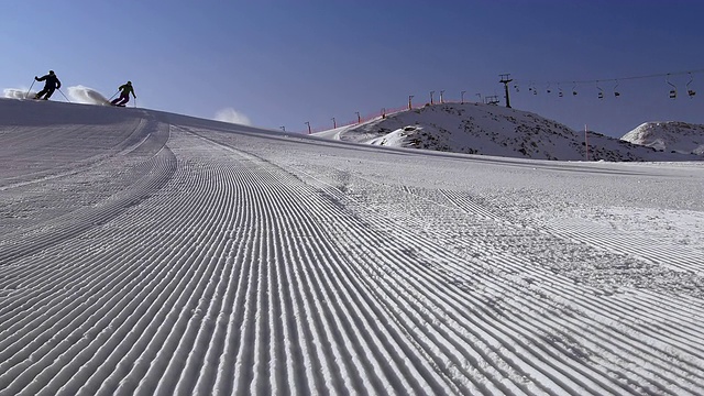 SLO MO DS夫妇滑雪整洁的阳光跑道视频素材