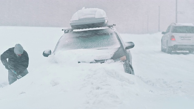 一名男子正在把他的车从雪中挖出来视频下载