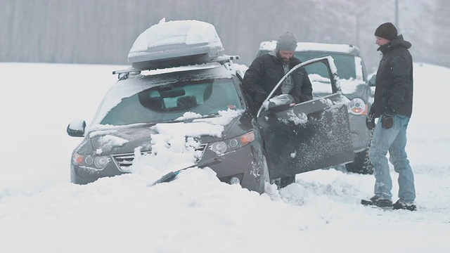路过的司机正在帮助一个人把车从雪中挪出来视频素材