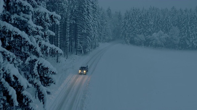 夜间，所有地形车辆行驶在被雪封的森林道路上视频购买