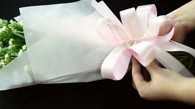 在婚礼花束上系上粉红色的蝴蝶结视频下载