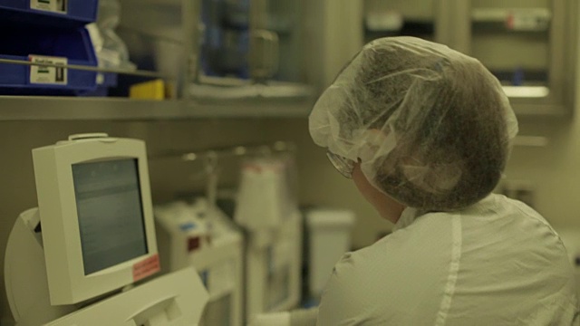 实验室工作人员使用小瓶和钢瓶执行医疗任务的CU视频素材