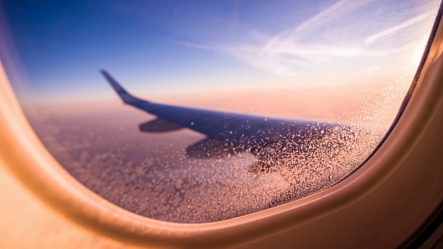透过飞机窗户观看橙色的云和天空视频素材