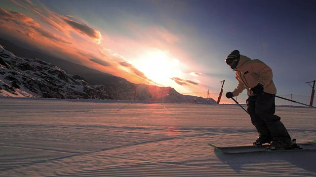 SLO MO TS自由式滑雪者在日落时滑下斜坡视频素材