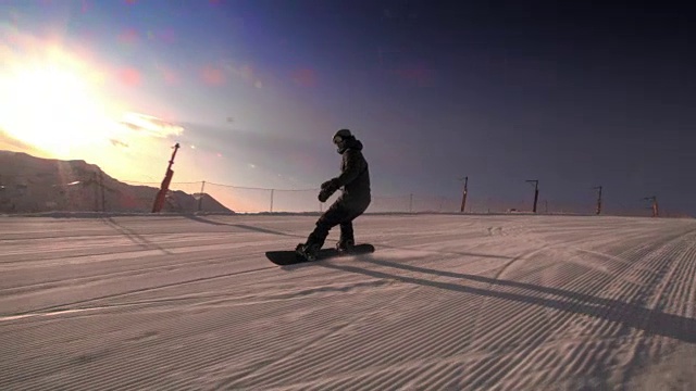 SLO MO TS滑雪板在日落时骑下斜坡视频素材
