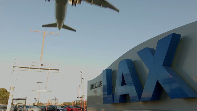 “欢迎来到洛杉矶国际机场”，前方有一架喷气式客机在接近着陆时从头顶飞过视频素材