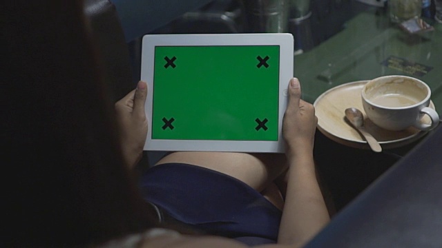 近距离观察手持绿色平板电脑的女性视频素材