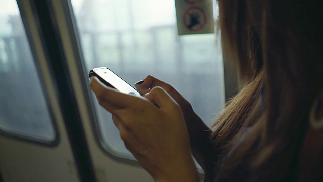 特写女人的手在火车上使用智能手机视频素材