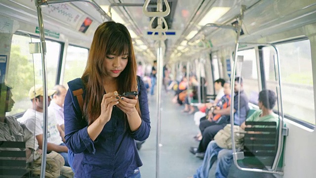 年轻女子在火车上使用智能手机视频素材