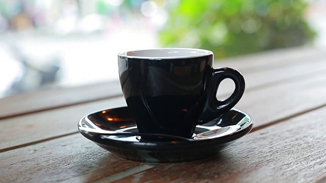 一杯热的意式浓缩咖啡放在户外的咖啡桌上视频下载