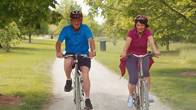 TS适合老夫妇骑自行车穿过公园视频素材
