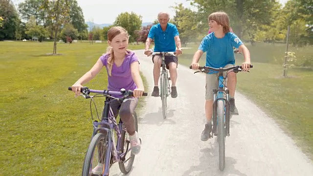 SLO MO孙辈和祖父母一起骑自行车视频素材