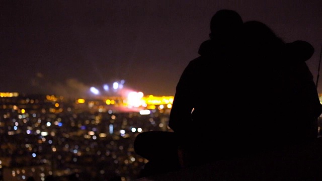 一对夫妇在山上观看巴塞罗那的烟花。视频素材