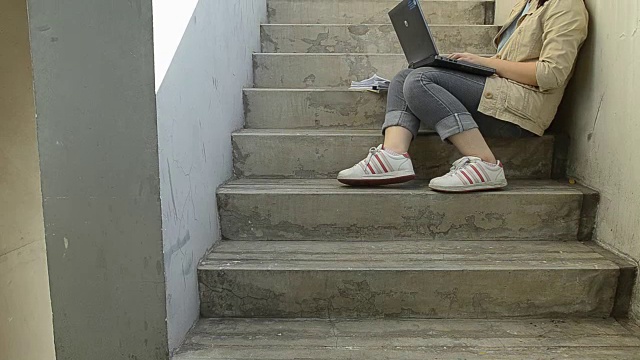 panning:忙碌的女商人坐在梯子上使用笔记本电脑视频下载