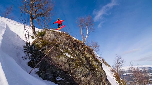 滑雪运动员从悬崖上跳下，落在刚下的雪上视频素材