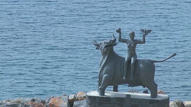 MS航拍宙斯雕像与欧罗巴和远处的海湾/ Agios Nikolaos，克里特岛，希腊视频素材