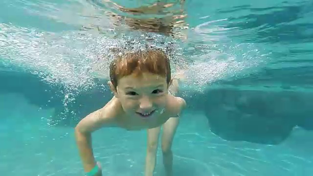 小男孩在游泳池里游泳视频素材
