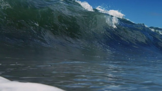 一个完美美丽的波POV波浪打破相机在加利福尼亚夏天的阳光浅沙滩上。慢动作在红龙上以300FPS的速度拍摄。视频素材