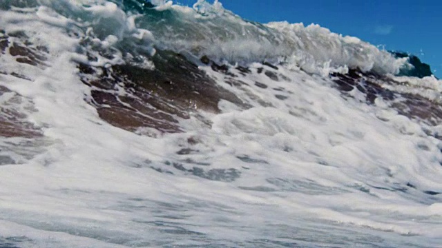 在一个炎热的夏天，泡沫美丽的波浪拍打在加利福尼亚的金色沙滩上。慢动作在红龙上以300FPS的速度拍摄。视频下载