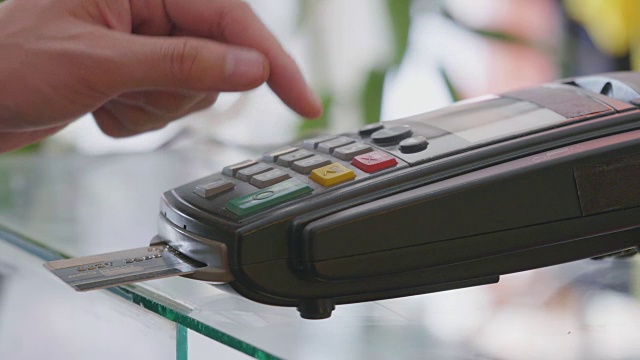 售货员将信用卡插入终端机并打字视频素材