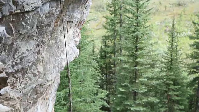 攀登者在山谷上方陡峭的悬崖上保护队友视频素材