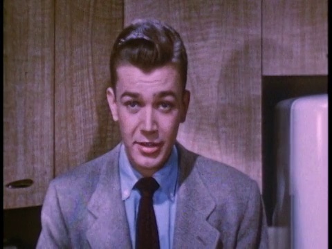 1952年，一个年轻人在厨房里和屏幕外的人聊天视频素材