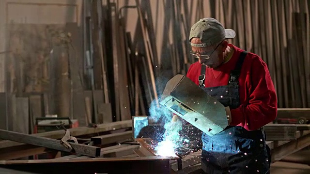SLO MO DS男工人焊接一块金属视频素材