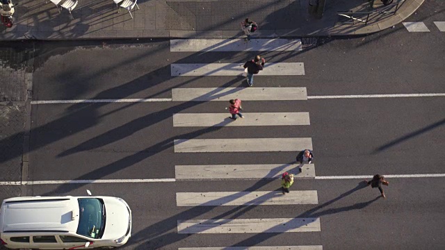 4K空中广角拍摄的人行横道。马德里这个十字路口的交通很流畅。行人过马路。我们可以看到下午侧面人影和车辆。视频素材