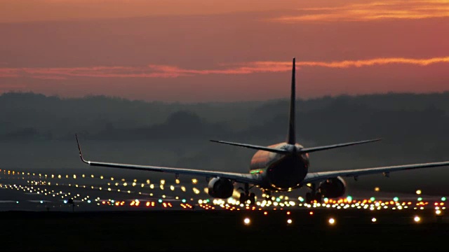 喷气式飞机在日落时沿着跑道飞行视频素材