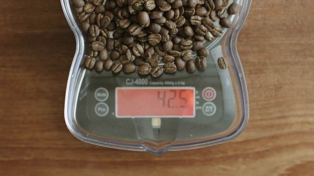 用磅秤称重烘焙过的咖啡豆视频素材