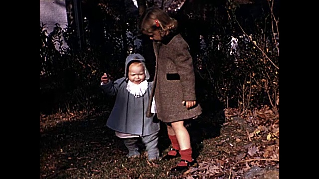 1940年的今天，一个小女孩教小妹妹走路视频素材