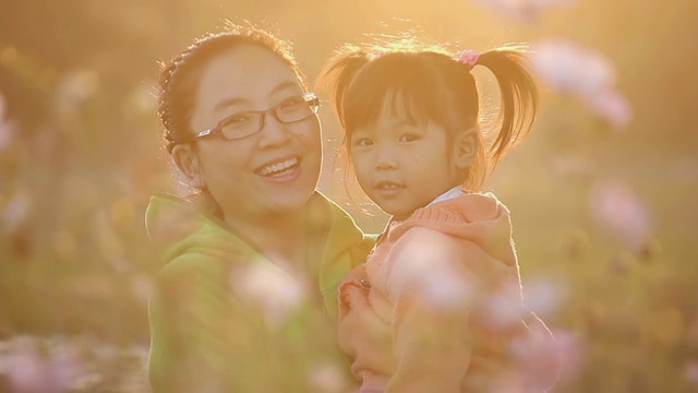 日落时分，母亲和女儿在花园中心玩耍的合影/陕西西安，中国视频素材