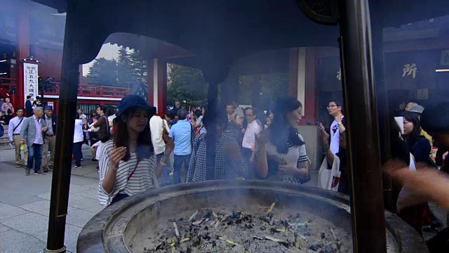 东京，日本浅草寺，人群聚集在东京最古老的寺庙，佛教徒在脸上抹烟祈祷视频素材