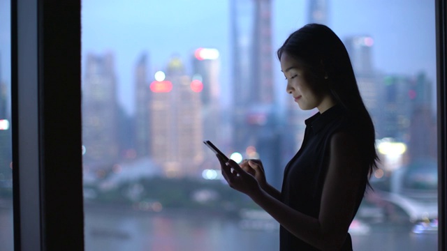 中国上海，一名年轻女子在窗边工作视频素材