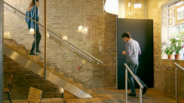 创意专业人士在现代办公空间的楼梯上聊天。视频素材