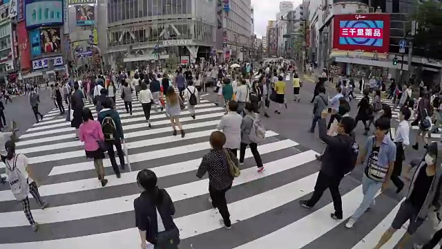 日本东京，熙熙攘攘的涉谷车站地区的Shibuya十字路口，熙熙攘攘的街道和人行道上到处都是当地人视频素材