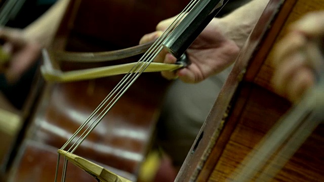 在管弦乐队中，弓在大提琴弦上视频下载