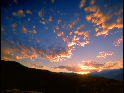 低角度广角时间推移云在蓝天上的轮廓山在日出/博尔德，科罗拉多州视频素材