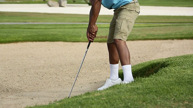 高尔夫球手想把球从沙坑里拿出来视频素材