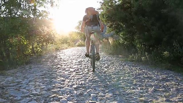 骑山地车的人爬上鹅卵石小路，日出视频素材