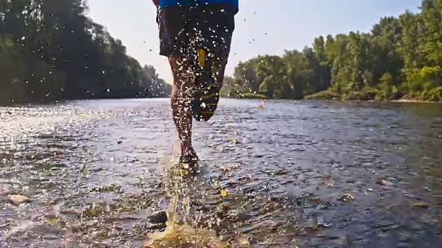 一个男人在一条浅河里奔跑视频素材