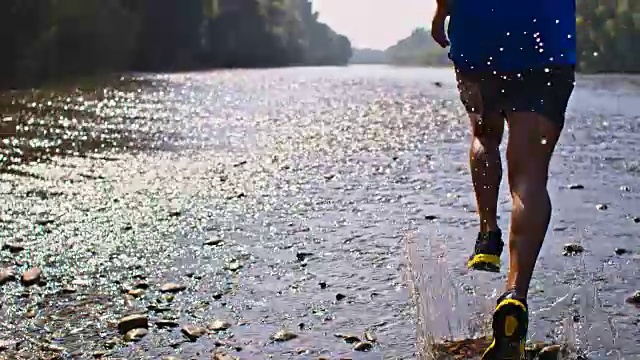 SLO MO年轻人在河边慢跑视频素材