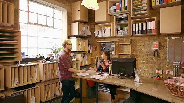 男员工和女员工在创造性的办公空间里讨论工作。视频素材