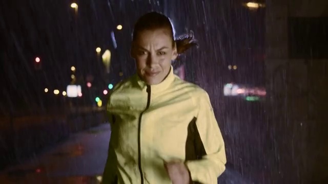 一个雨夜在城市里奔跑的女人视频素材