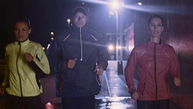 一个雨夜，朋友们在城市街道上奔跑视频素材
